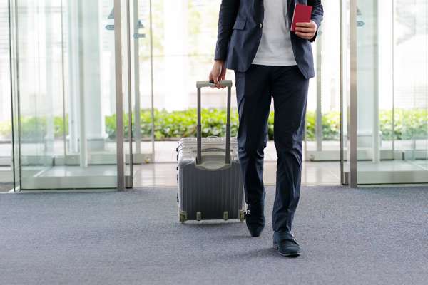 Mann mit Koffer am Flughafen